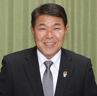 黒スーツに白ワイシャツ、灰色系のネクタイを着用した今井町長の写真