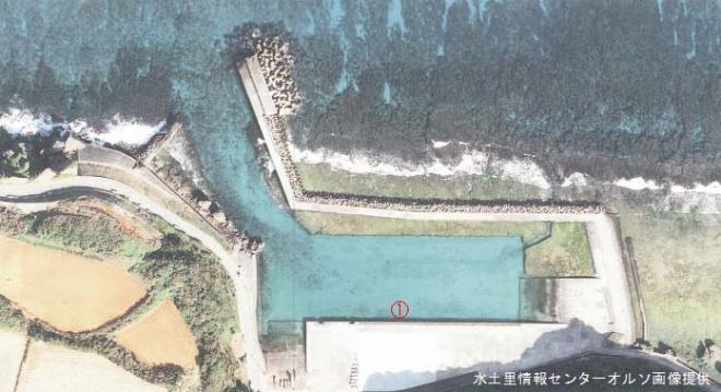 防波堤で囲まれた人工的な入り江が映る航空写真で、湾内には青い水面があり、中央に赤丸で囲まれた「1」の数字が示されている写真