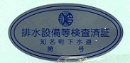 青い楕円形のシールに知名町の町章のようなシンボルマークと「排水設備等検査済証知名町下水道第号」という文字が青で印字された検査済証の写真