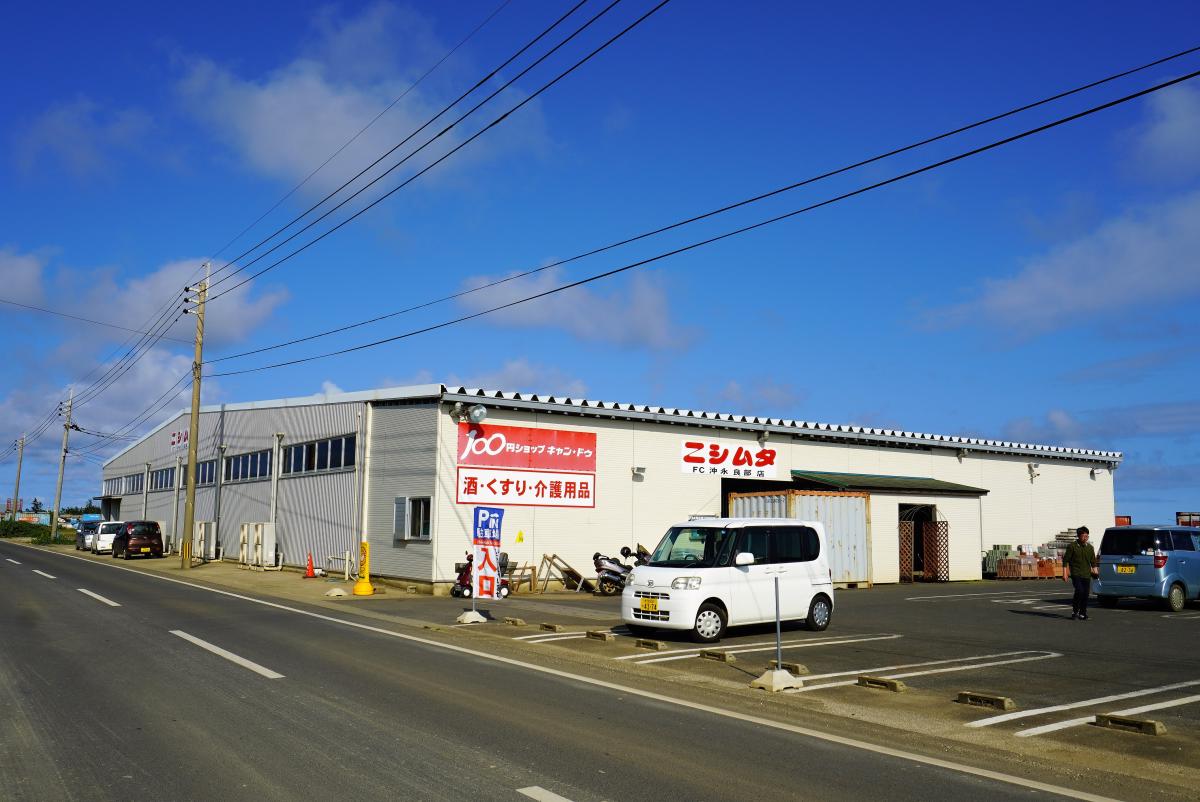 広い駐車場に面した倉庫のような平屋の建物に、「100円ショップキャン・ドゥ」「ニシムタ FC沖永良部店」の看板などが掲げられている店舗の外観写真