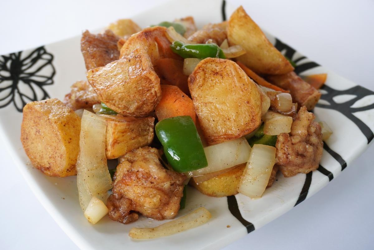 角切りのじゃがいもと鶏肉を中心に、緑のピーマンや玉ねぎ、にんじんを炒めた料理の写真