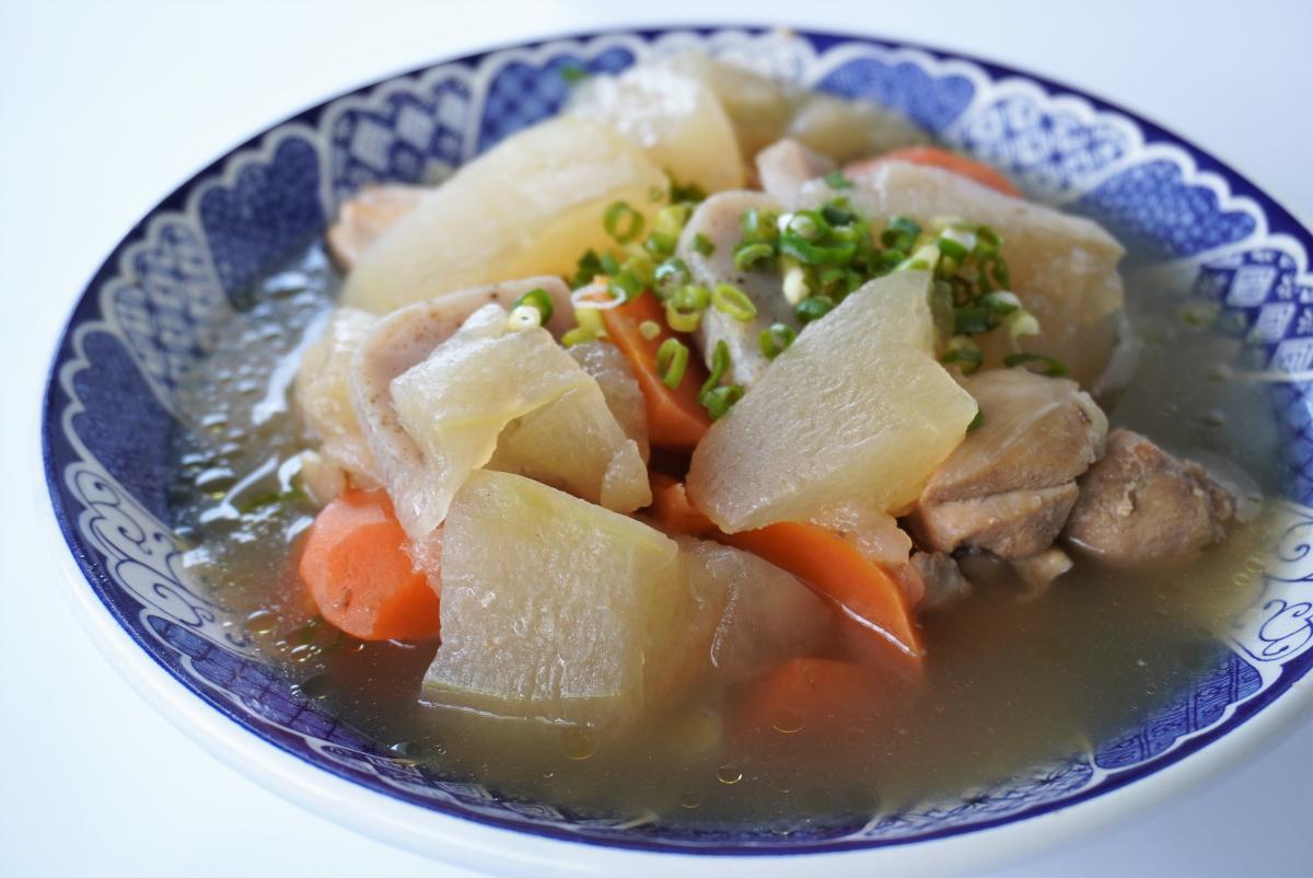 大きめに切った冬瓜とにんじん、鶏肉を煮込み、青ねぎを散らした汁物の写真