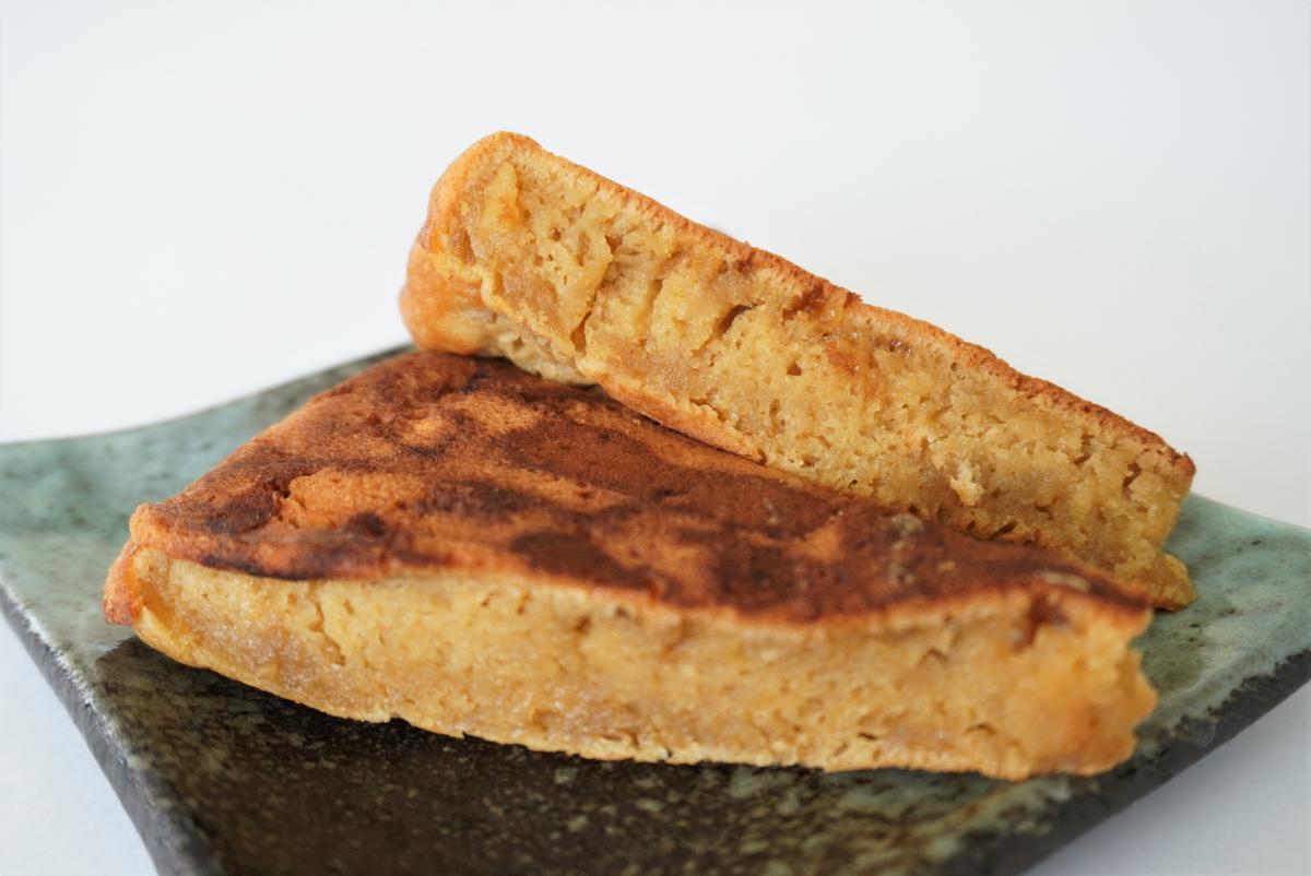 焼き色のついた厚みのあるケーキ状の生地が二切れ、断面にしっとりした質感を見せながら盛られている写真