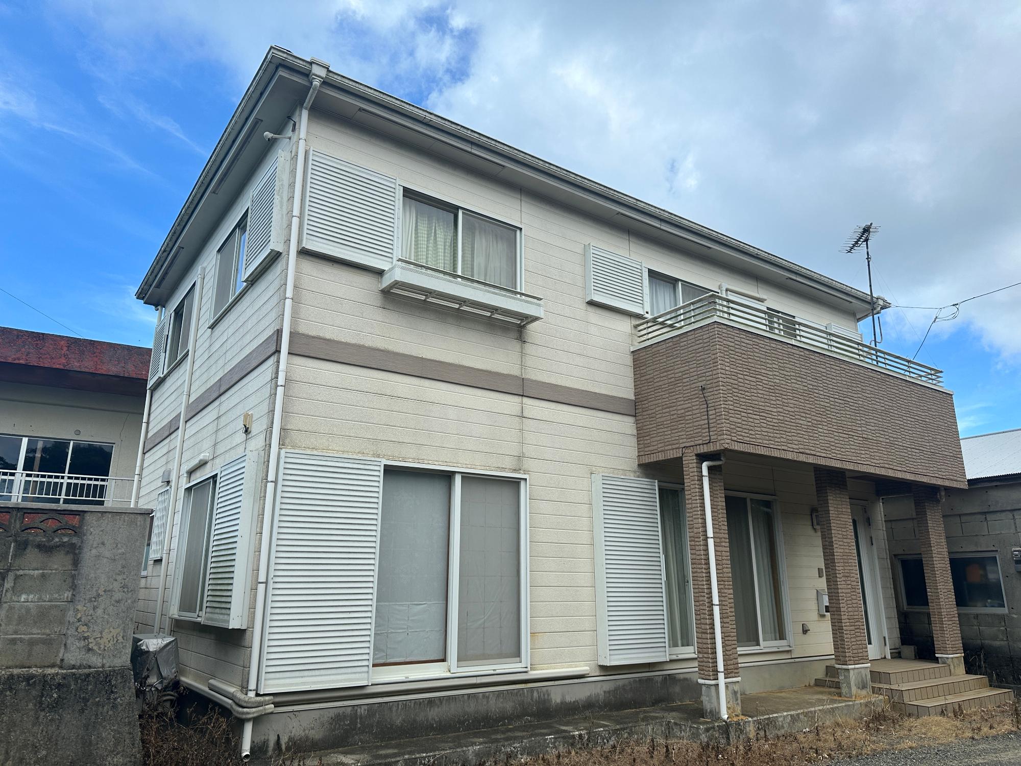 白色の外壁で、茶色のバルコニーが特徴的な2階建ての戸建て住宅No.98の物件の外観写真