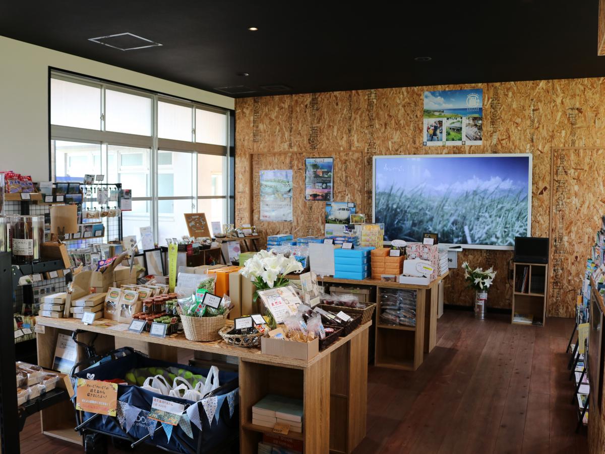 地元の特産品や土産物が陳列された、明るい物産販売所内の写真